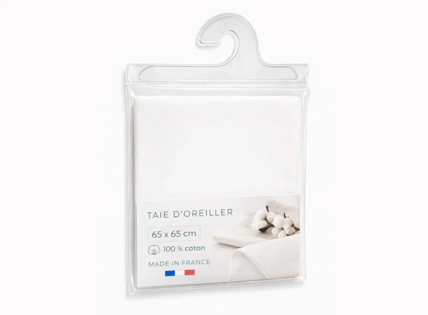 Taie d'oreiller blanche 65x65 cm en coton 100% emballée dans pochette plastique suspendue, étiquette «Made in France».