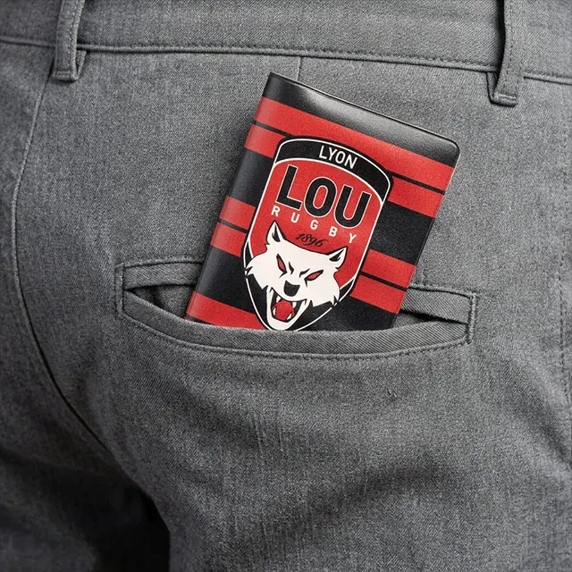 Portefeuille rouge et noir à logo LOU Lyon Rugby avec tête de loup dépassant d'une poche arrière de pantalon gris.