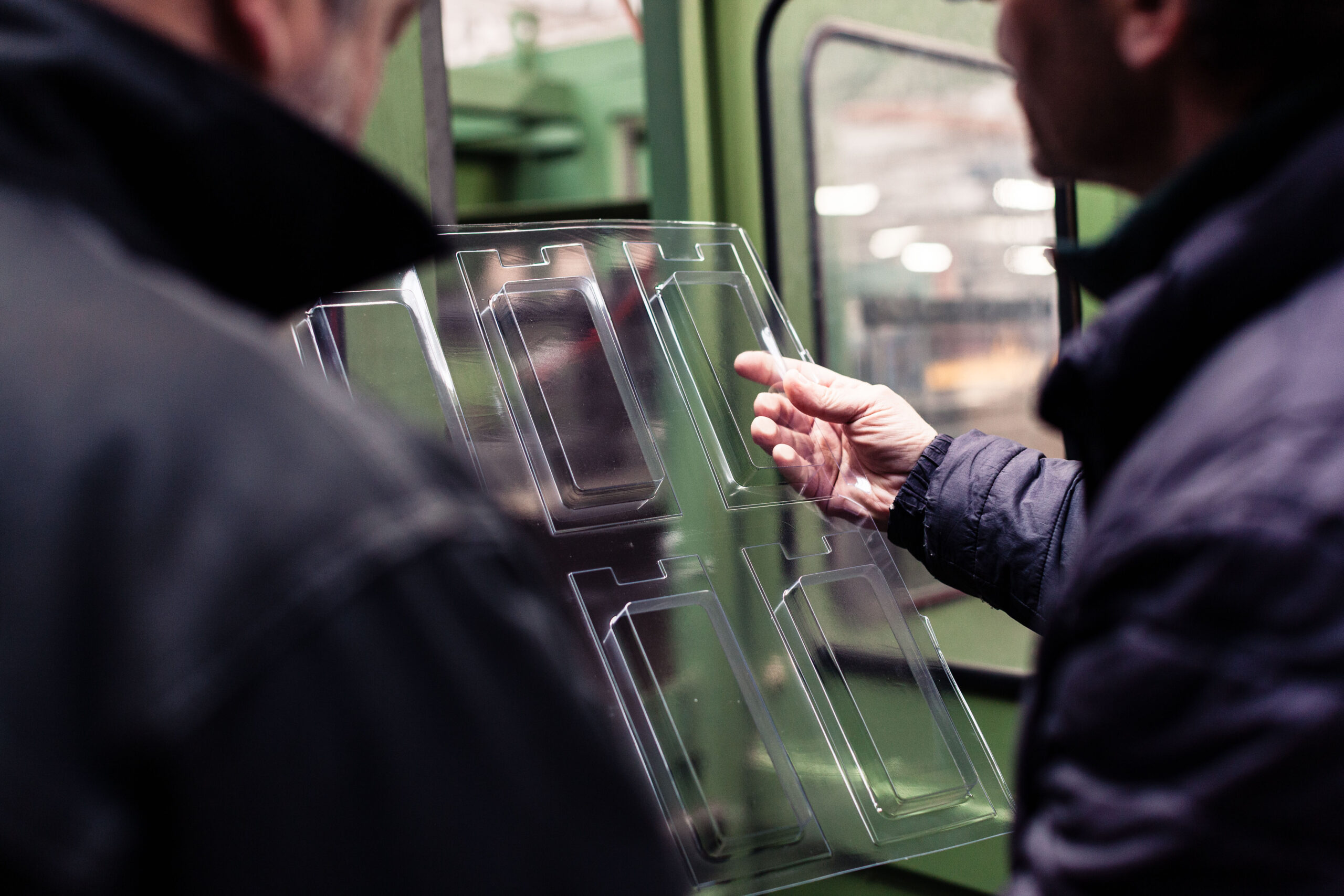 Suggestion de 2 hommes en train d'analyser la qualité d'un blister en sortie de machine