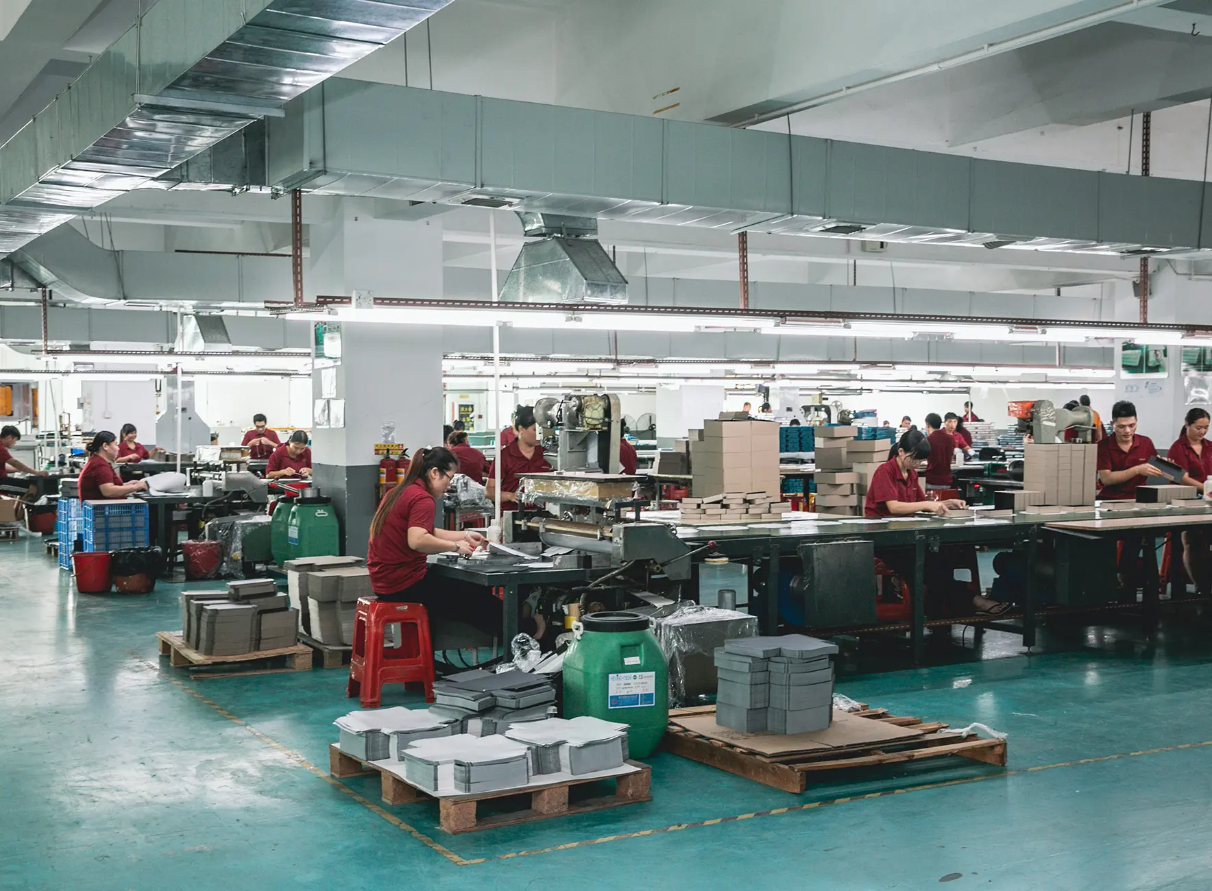Atelier de production à Dongguan avec opérateurs travaillant sur une ligne d'assemblage